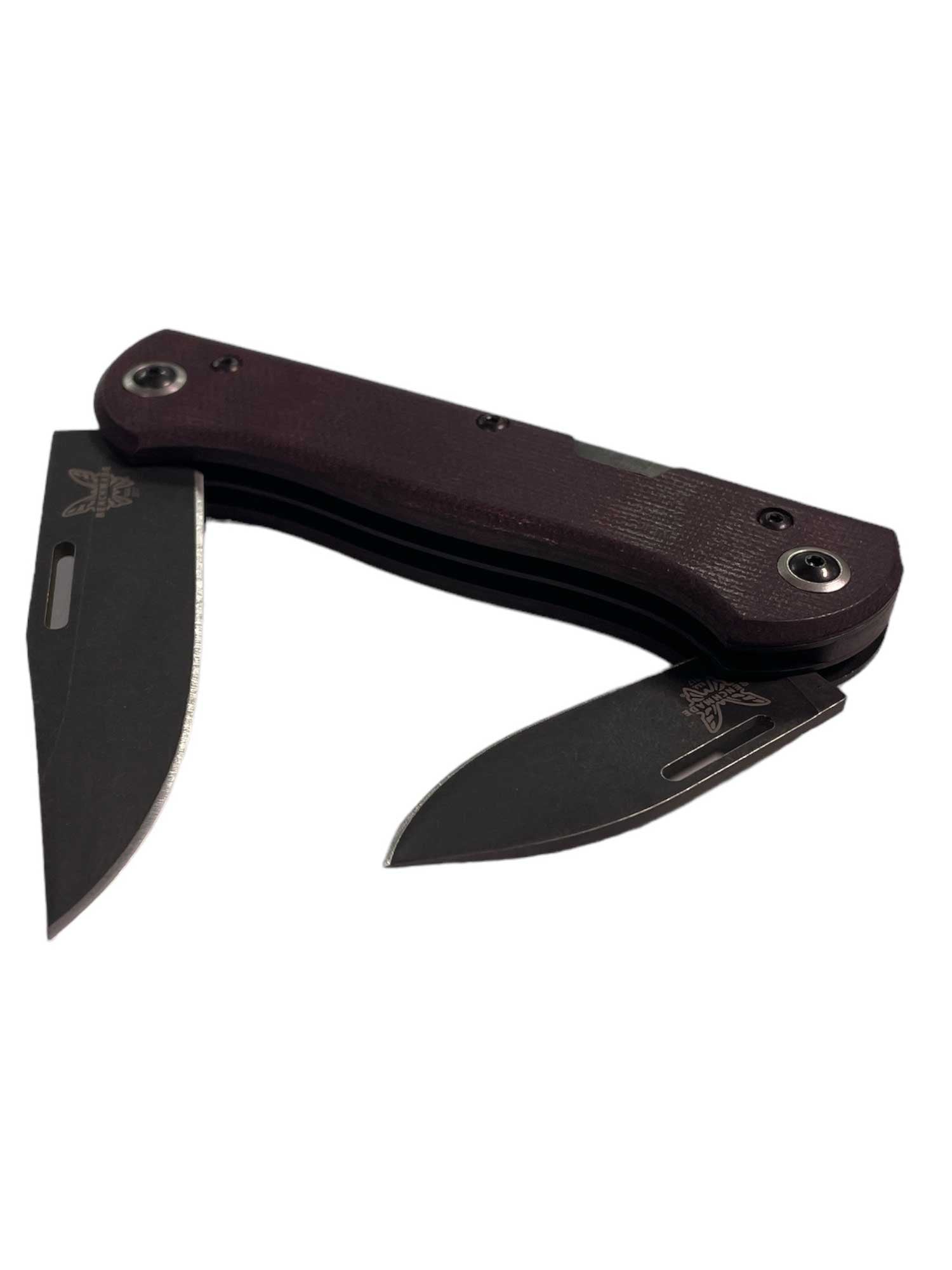 The Benchmade Weekender Slip Joint Knife features two partially open dark blades and a maroon handle, displayed against a white background.