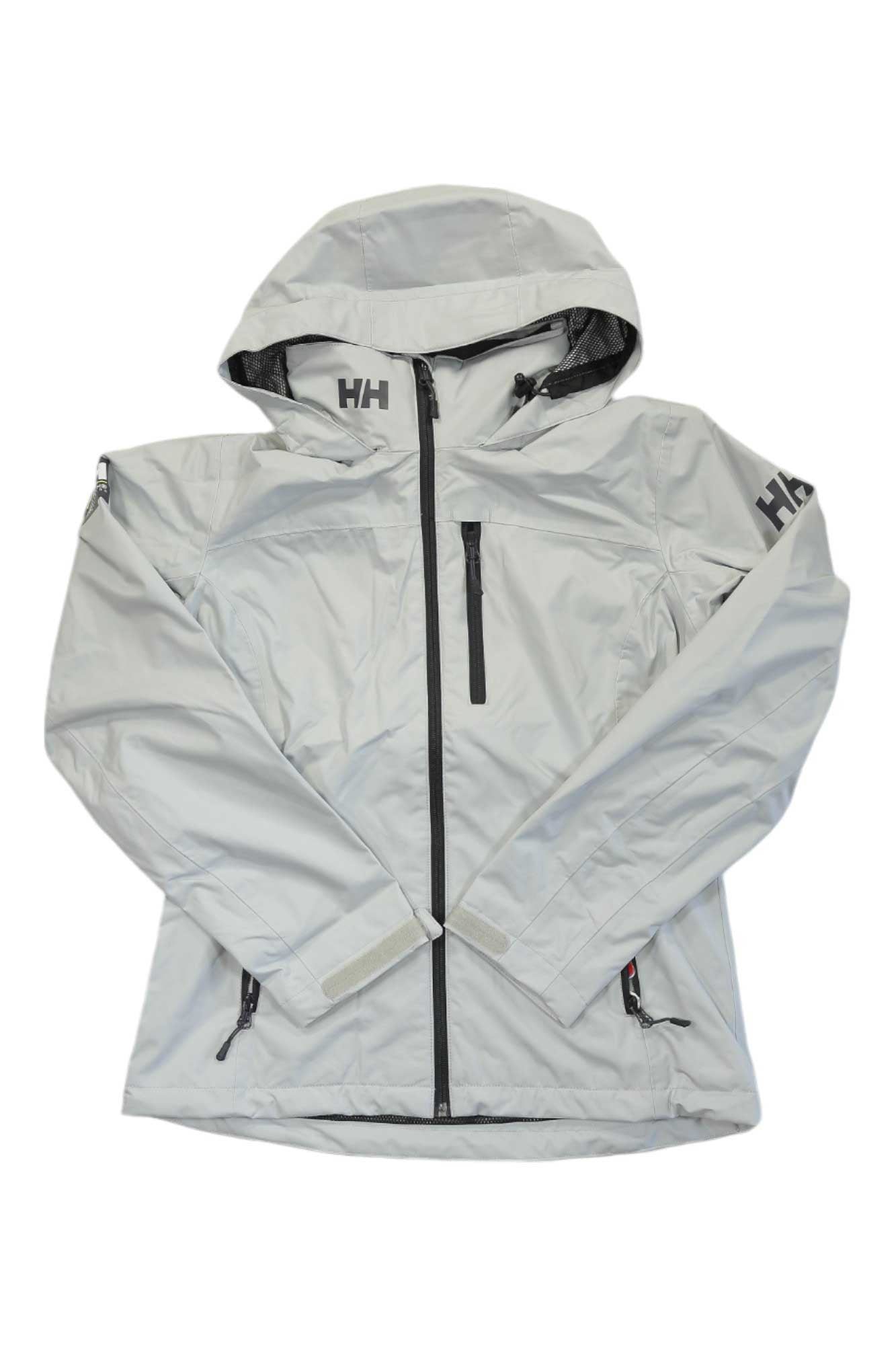 The Helly Hansen Womens Crew Hooded Jacket is light gray with black zippers, a chest pocket, HH logos on the left chest and sleeve, and long sleeves. It’s shown flat against a white background.