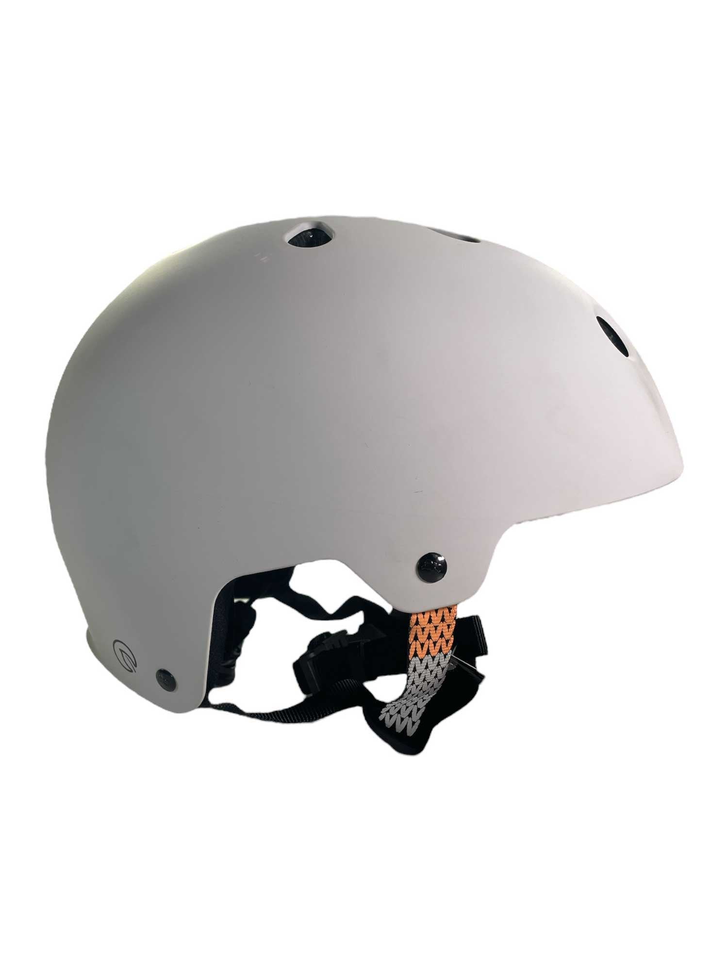 The Kali Protectives Saha Helmet is an eco-friendly white helmet with ventilation holes, adjustable black straps, and an orange patterned chin strap, made from recycled EPS foam. Shown from a side angle against a white background.