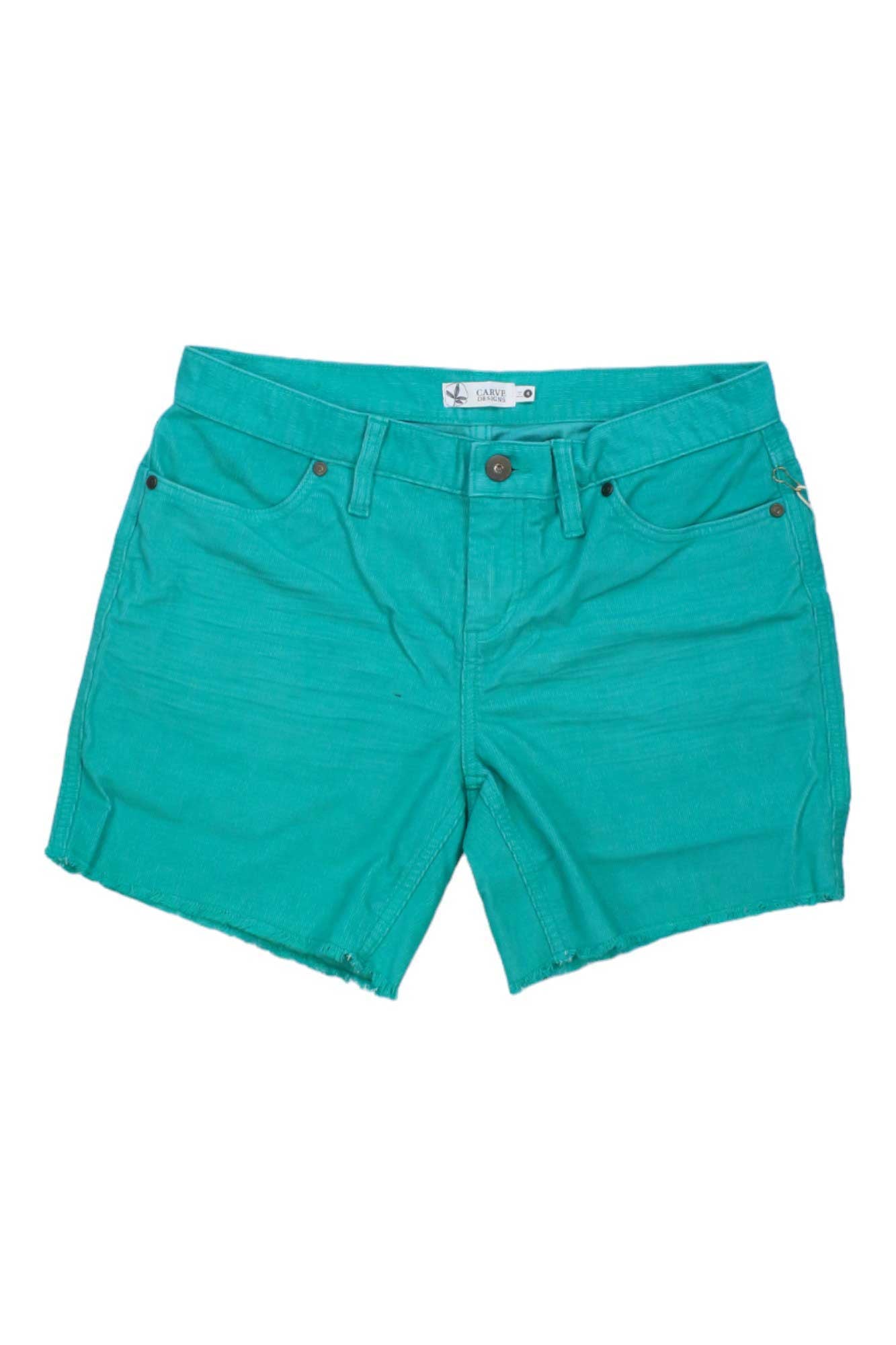 The Carve Designs Womens Oahu 6 Inch Short is a bright teal pair made from organic cotton, featuring frayed hems, front and back pockets, belt loops, and a button closure.