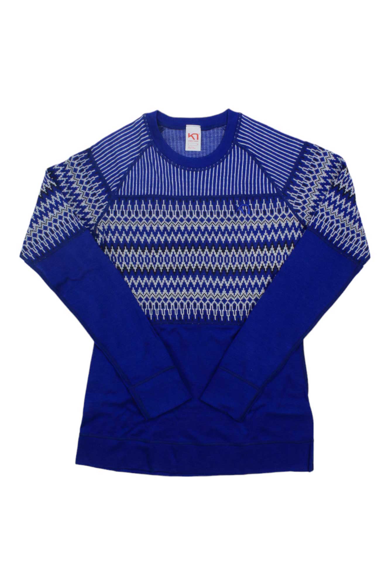 The Kari Traa Women's Silja LS Top is a royal blue, long-sleeve merino wool base layer with white geometric zigzag patterns on the chest, shoulders, and sleeves—ideal for cold weather. Displayed flat on a white background.