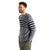A man with short curly hair, a beard, and a smile wears the Icebreaker Mens Waypoint Crewe Sweater in gray and navy with olive green pants, standing with his hands in his pockets against a white background.