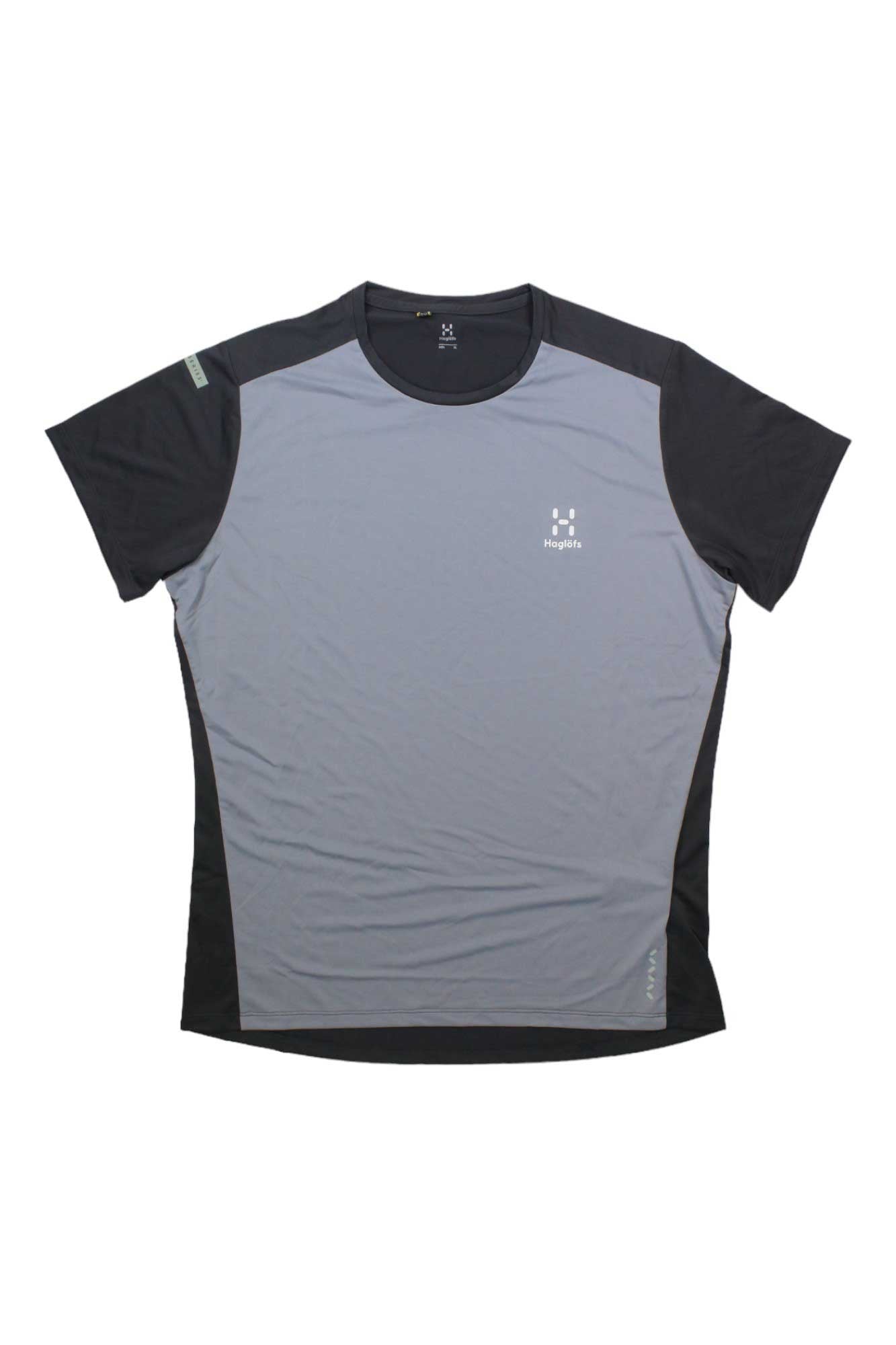 The Haglofs Mens L.I.M Tech Tee is a short-sleeved athletic shirt made from recycled polyester with a light gray front, black sleeves and sides, moisture-wicking fabric, and small logo/text accents on the left chest and right shoulder.