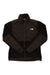 The Denali Jacket is a women's fleece by The North Face in black and dark brown, featuring long sleeves, side pockets, a stand-up collar, and the logo on the left chest. Made from recycled fleece for added sustainability.