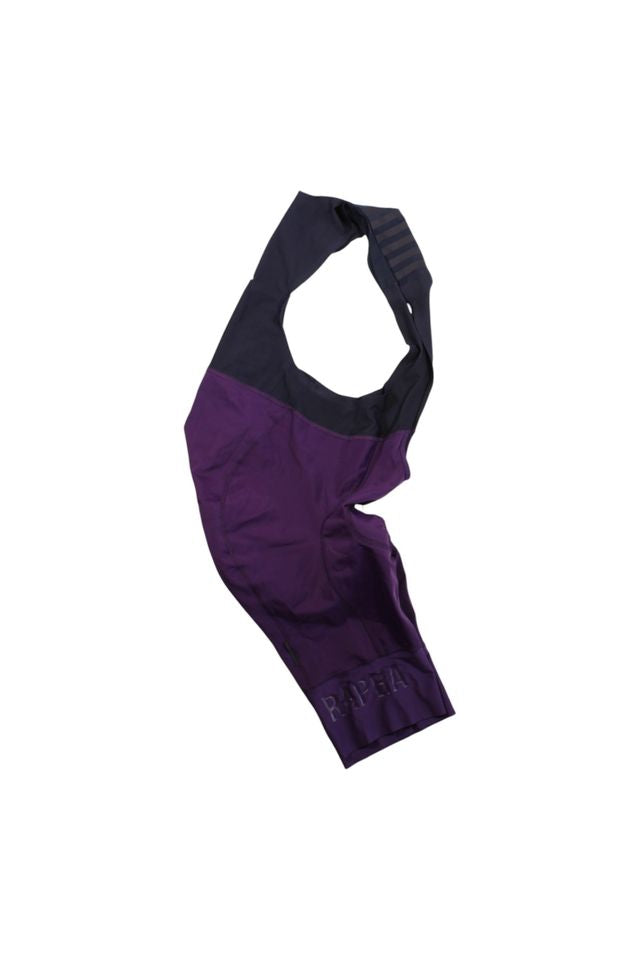A pair of Rapha Mens Pro Team Bib Shorts II - Long in purple and black, with a dual-density chamois pad and signature leg branding, laid flat on a white background.