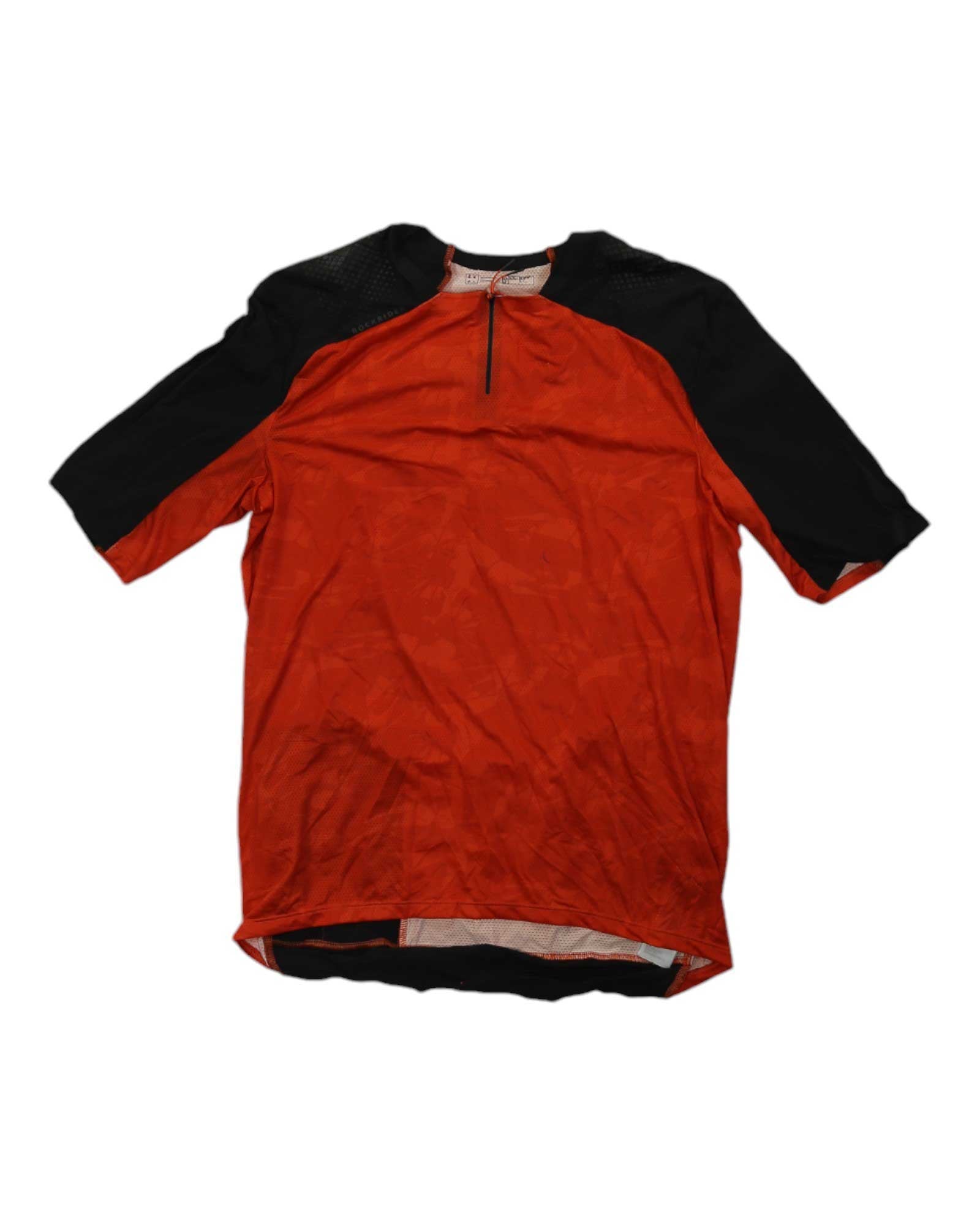 The Decathlon Mens Rockrider EXPL 500 Short Sleeve Jersey features an orange front, black sleeves and shoulders, moisture-wicking fabric, a small front zipper, and a slightly longer back hem for mountain biking comfort.