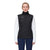 A person stands facing forward, wearing the Mammut Womens Albula IN Hybrid Vest—black with recycled synthetic insulation—over a white long-sleeve shirt and dark pants, set against a plain white background.