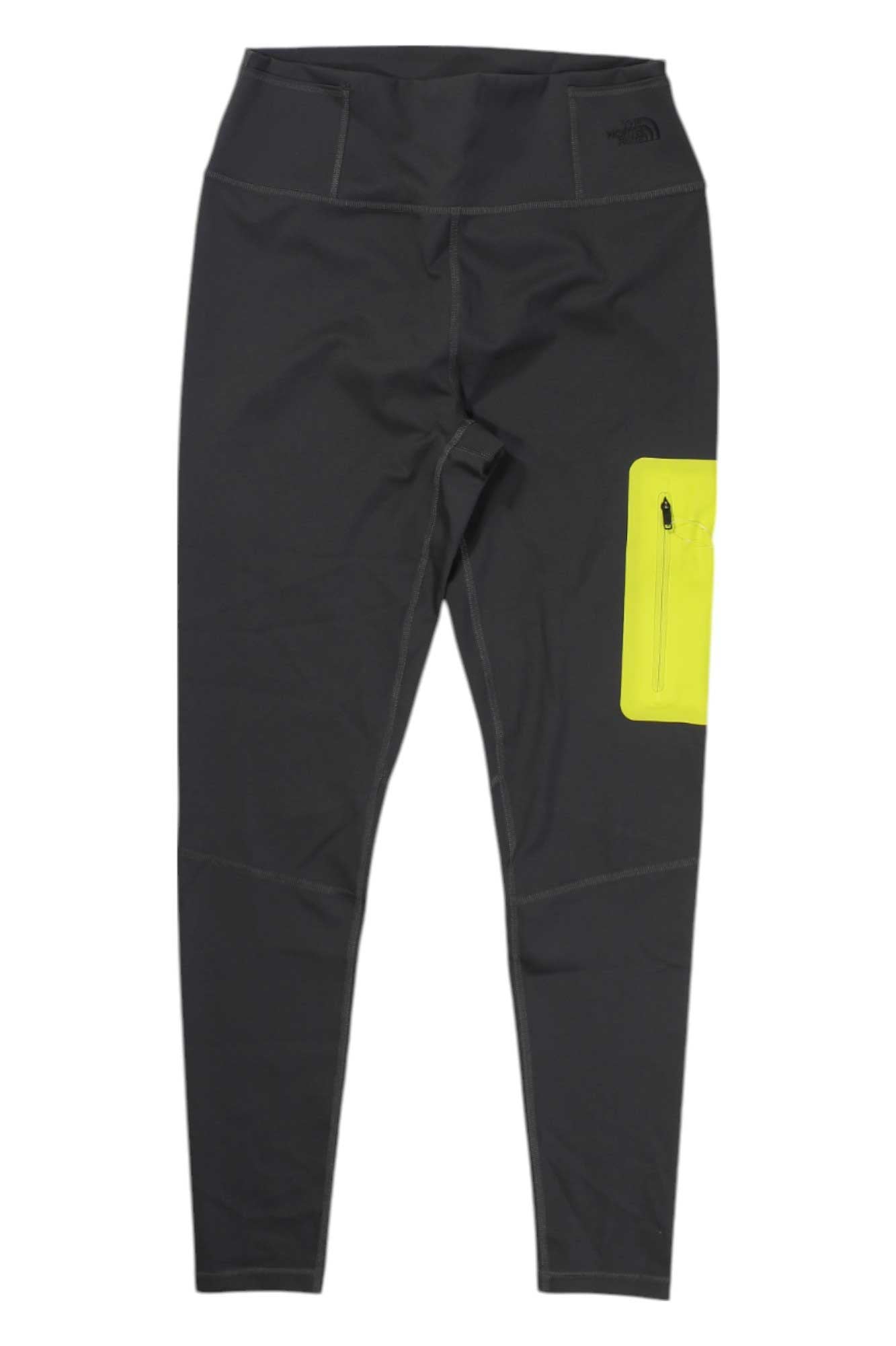 A pair of The North Face Women's Paramount Tight black high-rise leggings with a high waistband, FlashDry-XD technology, and a bright yellow zippered pocket on the upper right thigh.