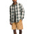 A person wears The North Face Mens Campshire Shirt, a green and white plaid button-front style, over a dark t-shirt and tan shorts against a plain white background. Their face is partially out of frame.