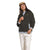 A woman wears The North Face Womens Campshire Fleece Jacket in brown over a light shirt, paired with beige pants and a tan cap, standing against a white background with a relaxed look and one hand in her pocket.