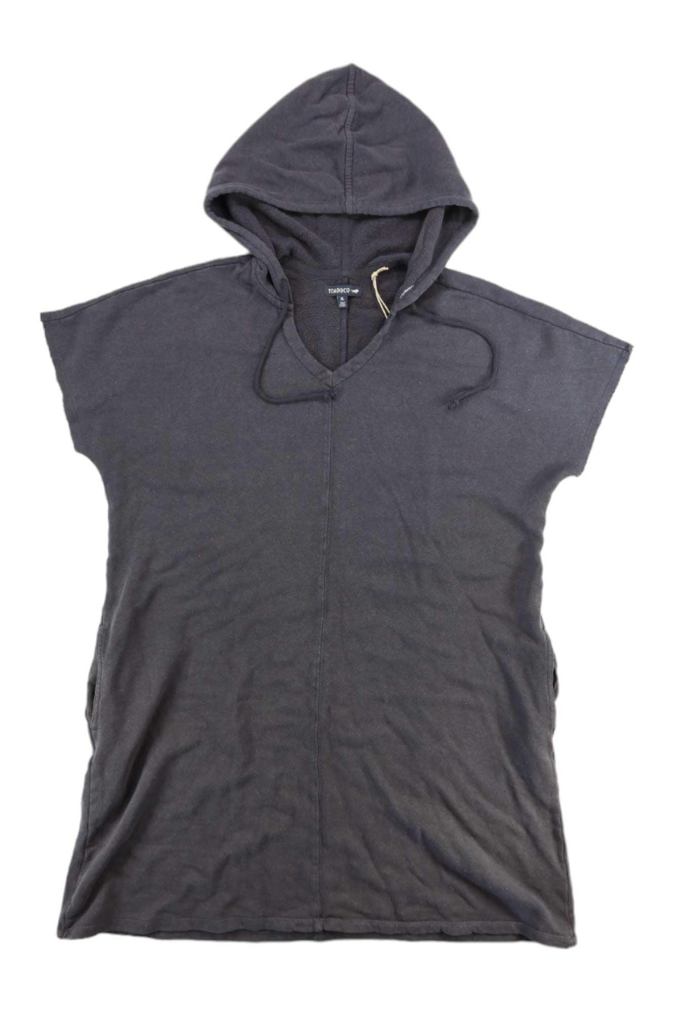 The Toad & Co Women's Epiq Hooded SS Dress is a short-sleeved, dark gray organic cotton dress with a hood, front seam, drawstrings, and relaxed fit, shown laid flat on a white background.