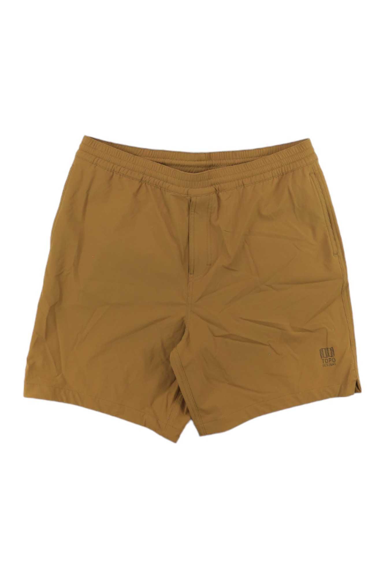 The Topo Designs Men's Global Short in light brown features 4-way stretch, an elastic waistband, and a small logo on the lower left leg, shown laid flat on a white background.