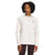 A woman, wearing The North Face Womens Heritage Patch Crew in light beige—crafted from recycled fabric—and dark pants, stands facing forward with hands at her sides, gazing slightly to the left.