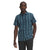 A man stands facing forward against a white background, wearing The North Face Men's Hammetts II SS Shirt—a casual blue and green plaid short-sleeve button-up—with one hand in his pocket and the other relaxed by his side.