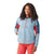A woman with curly hair smiles, wearing the Smartwool Womens Active Ultralite Anorak in light blue with red and dark blue accents and red leggings, standing against a white background.