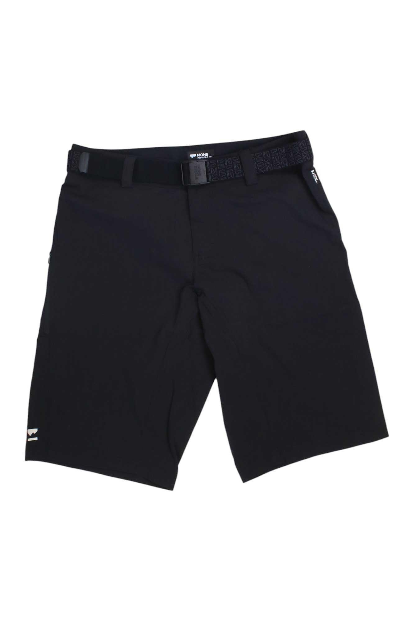 The Mons Royale Women's Virage Short is a pair of black, knee-length cycling shorts with a flat front, side pockets, matching black belt, and a small white logo on the bottom left leg for versatile style and comfort.