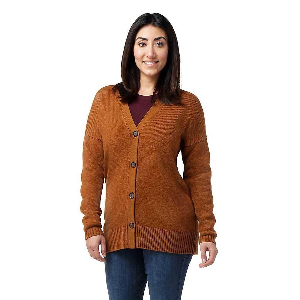 A woman with straight dark hair smiles, wearing the Smartwool Womens Cozy Lodge Boyfriend Cardigan over a maroon top and blue jeans, standing against a plain white background.