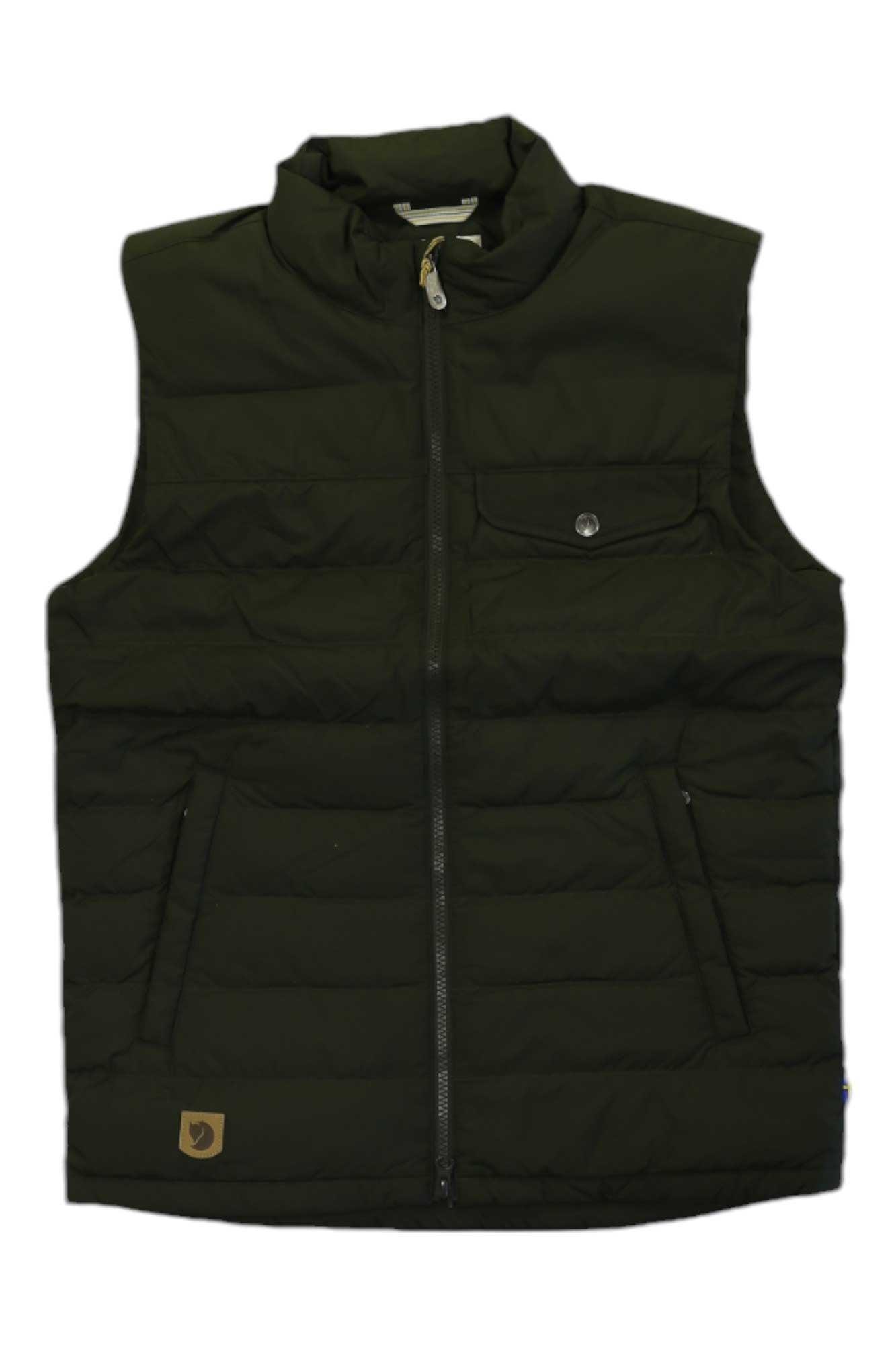 The Greenland Down Liner Vest is dark green, sleeveless, and insulated with recycled polyester. It has a front zipper, two zippered side pockets, a buttoned chest pocket, high collar, and a small brown logo patch near the hem.