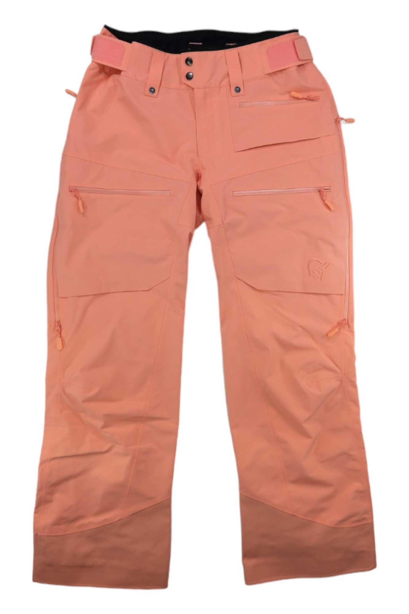 Norrona Womens Lofoten GORE-TEX Insulated Snow Pants in peach, waterproof with multiple zippered pockets, reinforced cuffs, belt loops, and an integrated belt. Shown laid flat on a white background.