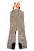 The Orage Mens Leeds Insulated Bib Pant in beige features black reinforced knees, bright orange suspenders, a front zipper, zippered chest pocket, side pockets, and is waterproof. Shown on a white background.