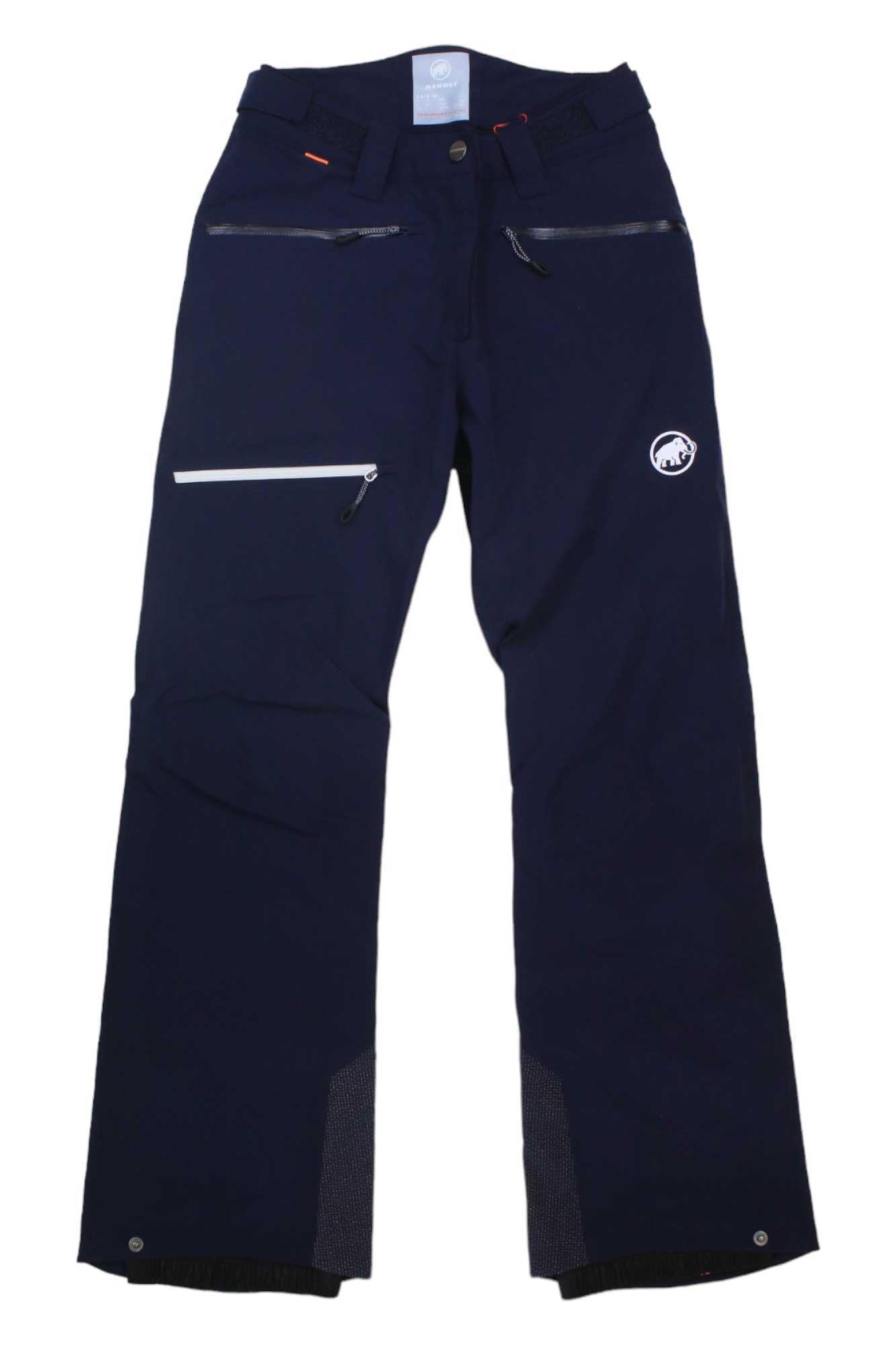 Mammut Womens Stoney HS Pants: Navy blue all-mountain hardshell ski pants featuring zippered pockets, a white logo on the left thigh, reinforced cuffs, and a reflective strip on the right thigh.