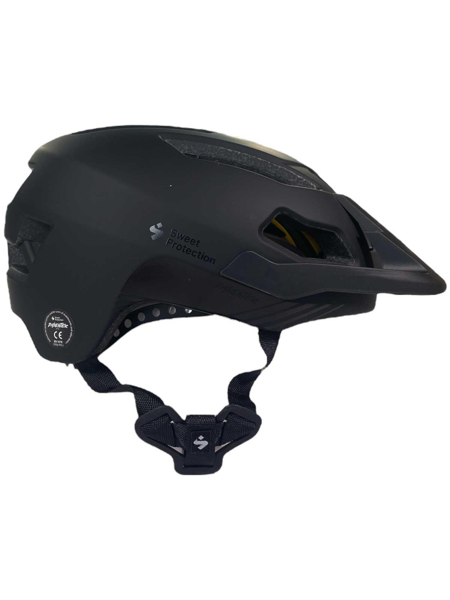 The Sweet Protection Men's Dissenter MIPS Helmet in black, designed for mountain biking, features a visor, adjustable chin strap, and ventilation openings. Side view shown.