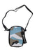 The Sherpani Women's Rogue Mini Crossbody Bag is a small women’s bag with a black strap, made from recycled polyester. It features blue, white, and gray geometric patterns, a black zipper, and a Sherpani tag.
