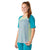 A young woman with long red hair in a ponytail is smiling and wearing the Smartwool Women's Merino Sport 120 Mountain Bike SS Tee in color-blocked teal, light blue, and green tones, with teal leggings, against a white background.