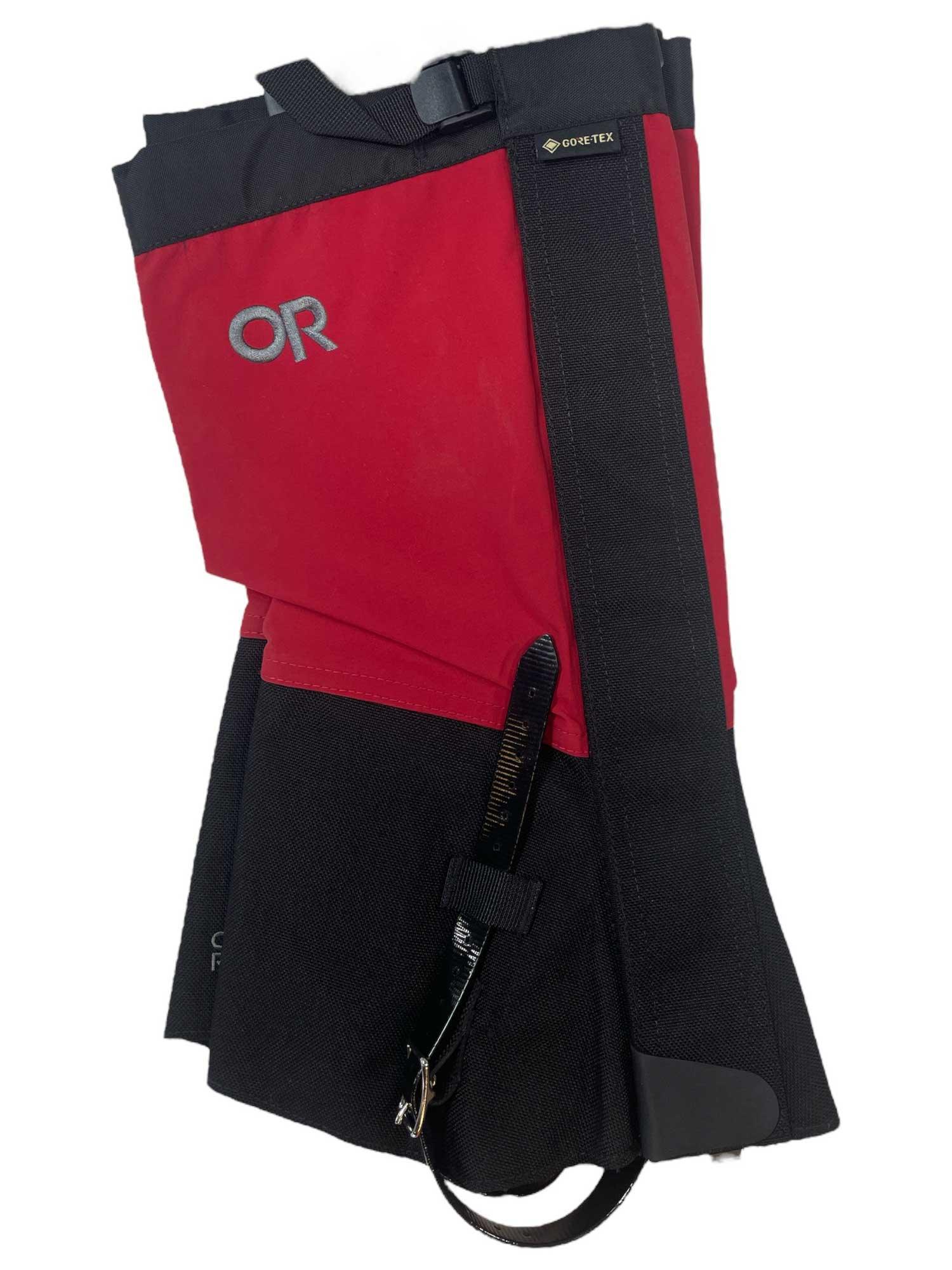 The Outdoor Research Crocodiles are red and black waterproof gaiters with abrasion-resistant fabric, a visible buckle strap, and a GORE-TEX label, designed to protect your lower leg and boot from debris and moisture.