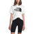 A woman stands against a plain background wearing The North Face Womens Half Dome Cotton SS Tee and black biker shorts. Her face is partially visible, and her arms hang relaxed by her sides.