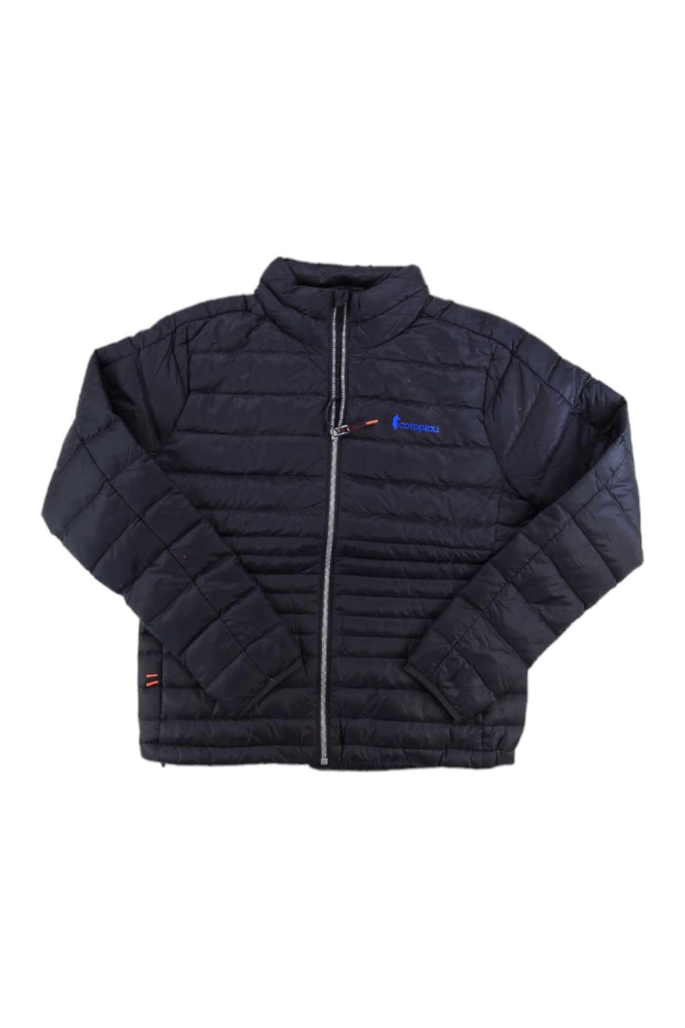 The Fuego Down Jacket is a black, quilted, packable insulated jacket with a front zipper, long sleeves, and a small blue logo on the left chest. It’s shown laid flat on a white background.