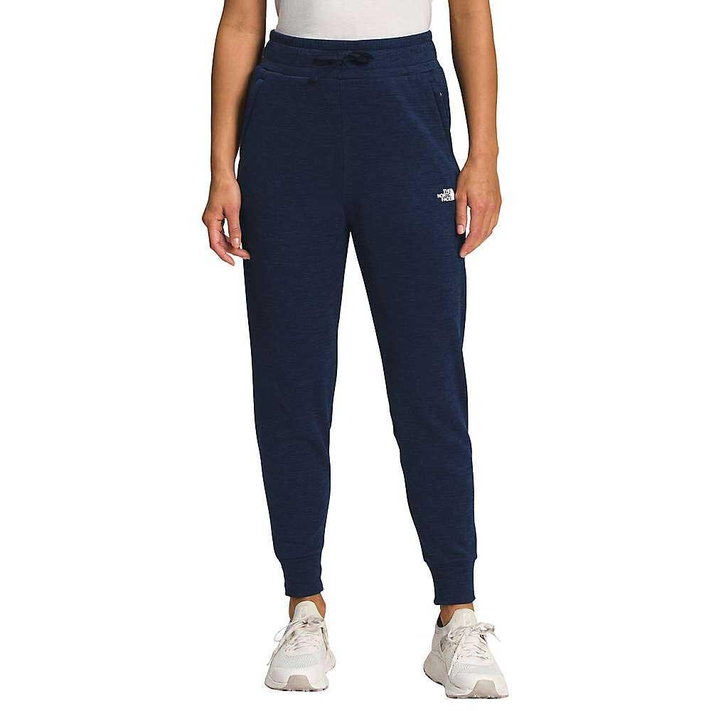 A person wears The North Face Womens Canyonlands Jogger in navy, paired with a white top and sneakers. The joggers have a drawstring waist and cuffed ankles, offering a cozy yet stylish appearance against a plain background.