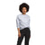 A woman with short curly hair wears The North Face Womens Heritage Patch Crew, a recycled-fabric sweatshirt, with black pants against a plain white background.