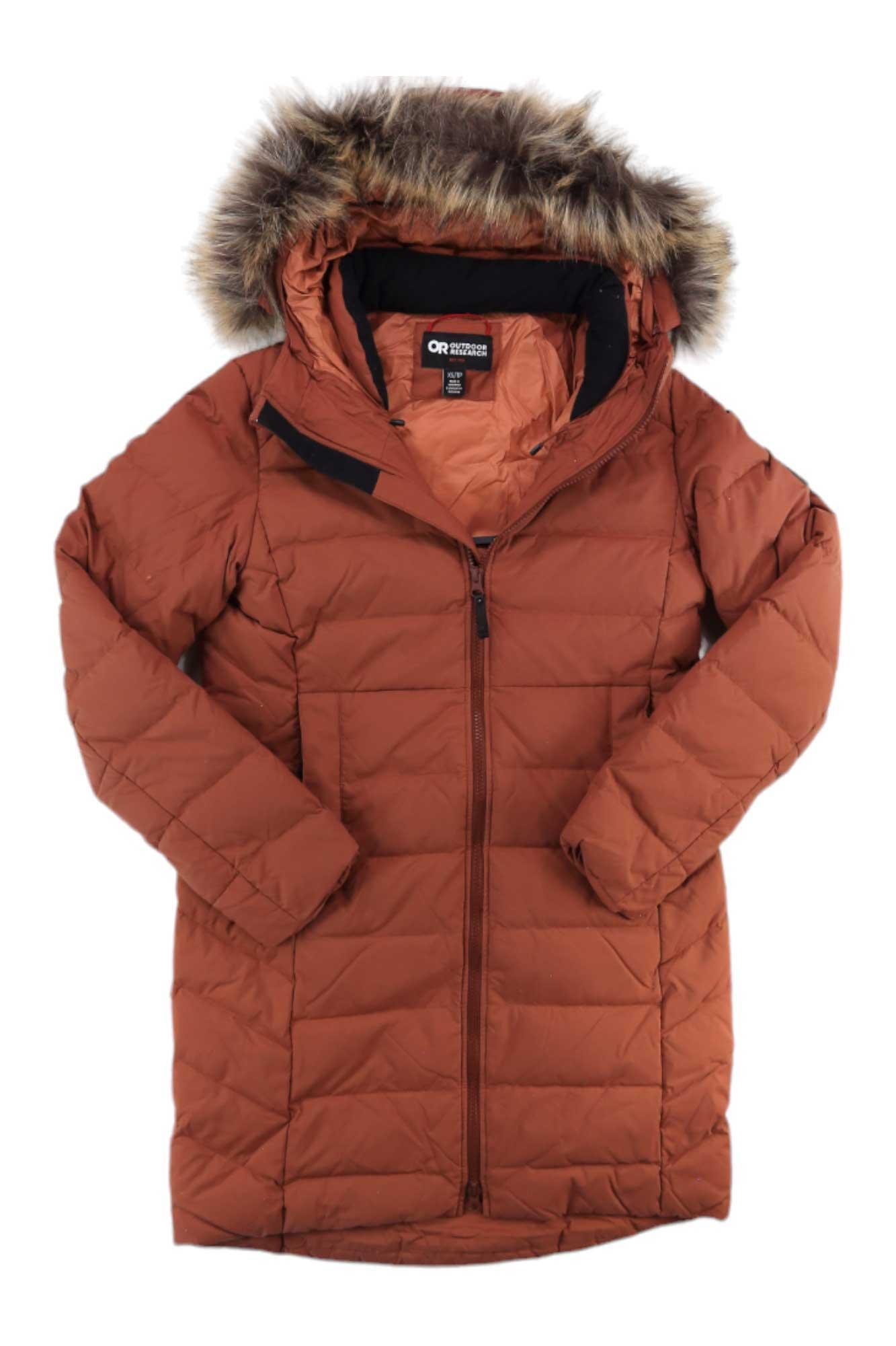 The Outdoor Research Women's Coze Faux Fur Parka is a rust-colored, knee-length jacket featuring a quilted design, long sleeves, front zipper, recycled nylon shell, and branded interior label.