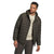 A man wears The North Face Men's Big Thermoball Eco 2.0 Hoodie in dark green over a beige graphic t-shirt and dark pants, standing against a white background and looking slightly to his left.