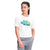 A young girl with braided hair wears The North Face Girls Graphic SS Tee featuring colorful, wavy logo text and light gray pants. She stands with one hand in her pocket, looking to the side against a white background.