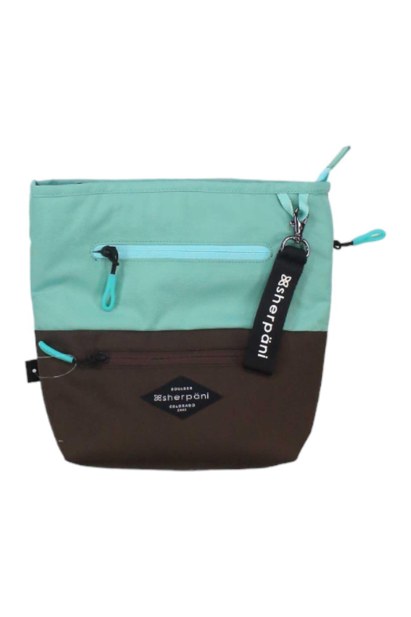The Sherpani Women's Sadie Cross Body Bag is a two-tone pouch made from recycled materials, with a teal top, brown bottom, two zippered pockets, teal pulls, and a black Sherpani keychain on the top zipper.