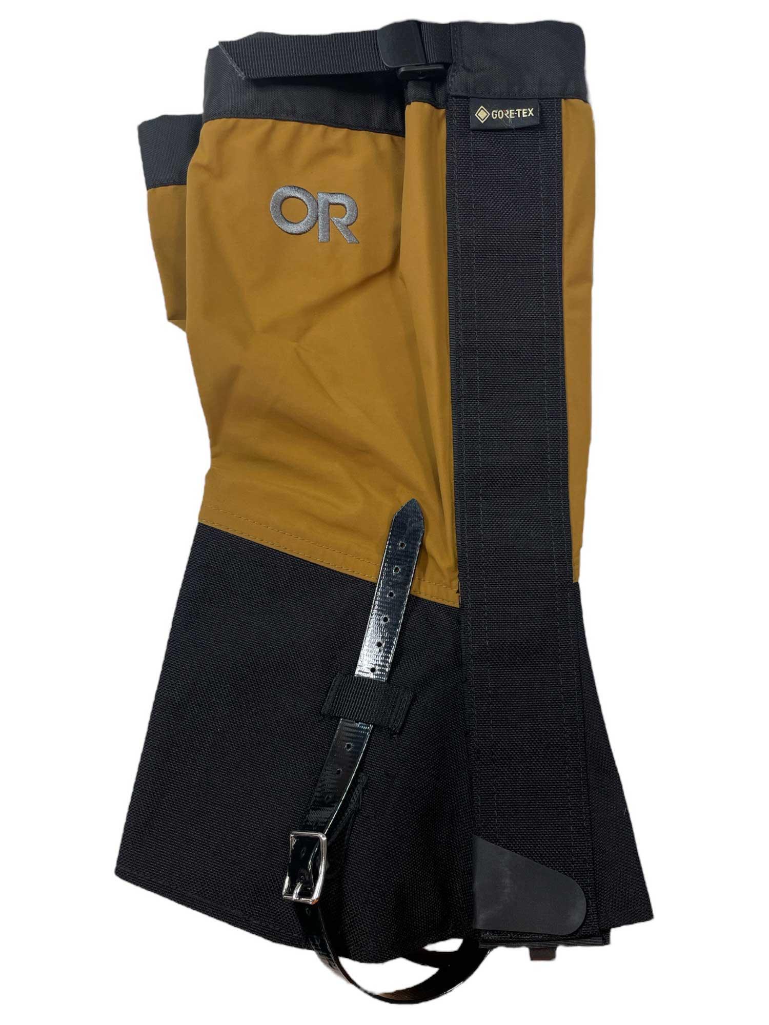 The Outdoor Research Crocodiles gaiter features brown and black waterproof, abrasion-resistant material with a Velcro closure, black strap and buckle, and OR and GORE-TEX logos on the upper section.