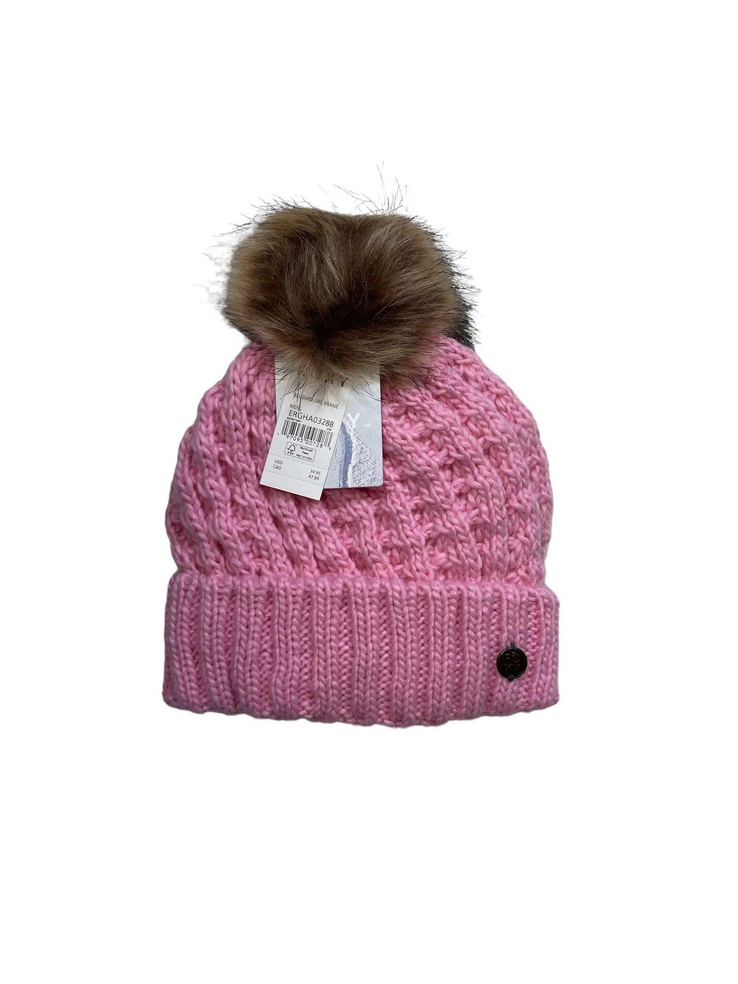 The Roxy Girls' Blizzard Beanie is a pink winter hat with a brown faux fur pom, folded brim, small black front button, cozy fleece-lined interior, and attached product tags.
