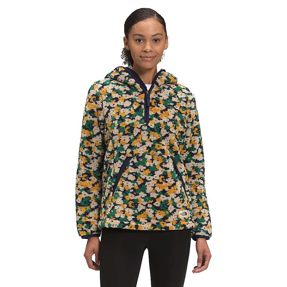 A woman stands facing forward in The North Face Women's Campshire Pullover Hoodie 2.0, featuring a colorful floral pattern and long sleeves, made from soft Sherpa fleece.