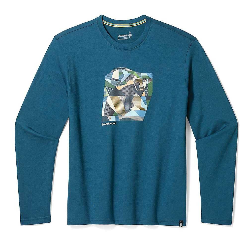 The Smartwool Bear Country Graphic LS Tee is a long-sleeved teal Merino wool shirt with a multicolored geometric bear graphic and Smartwool logo, ideal for hiking. Displayed flat on a white background.