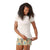 A woman with curly hair smiles and looks down while adjusting her Smartwool Womens Denver Skyline Graphic SS Tee, paired with yellow floral shorts against a plain white background.