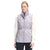 A woman stands facing forward, hands at her sides, wearing The North Face Women's Westcliffe Down Vest in light purple with Heatseeker Eco insulation over a cream long-sleeve shirt. The vest has a quilted design, high collar, and cinched waist.