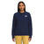 A woman with long, straight dark hair wears The North Face Womens Heritage Patch Crew in navy blue and yellow pants, standing facing forward against a plain white background.