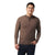 A man wearing a brown Smartwool Mens Sparwood Half Zip Sweater and dark jeans stands against a plain white background, smiling with one hand in his pocket.