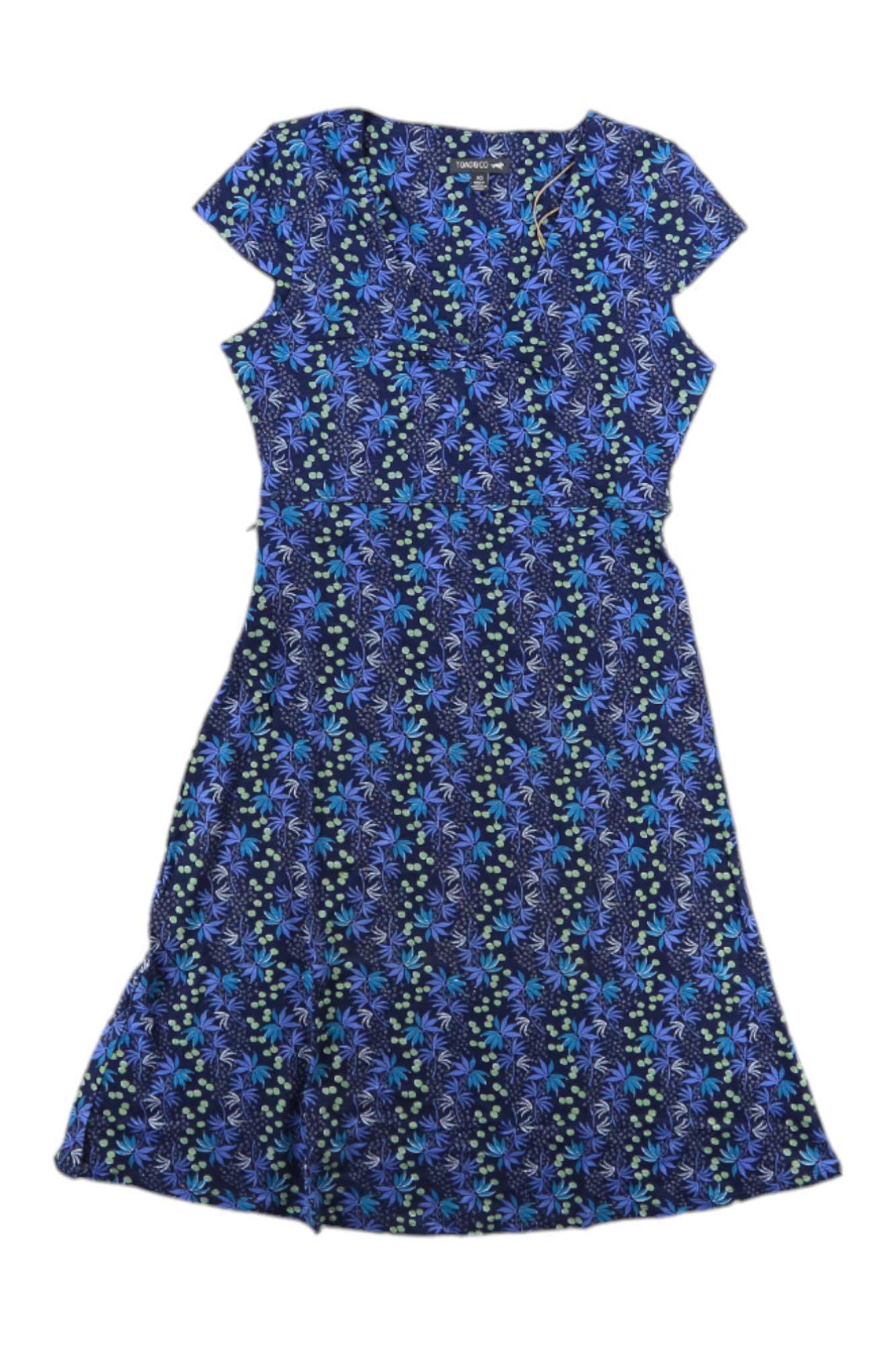 The Toad & Co Women's Rosemarie Dress is a short-sleeved, knee-length organic cotton dress featuring a blue and green floral pattern on a dark background, shown flat on a white surface.