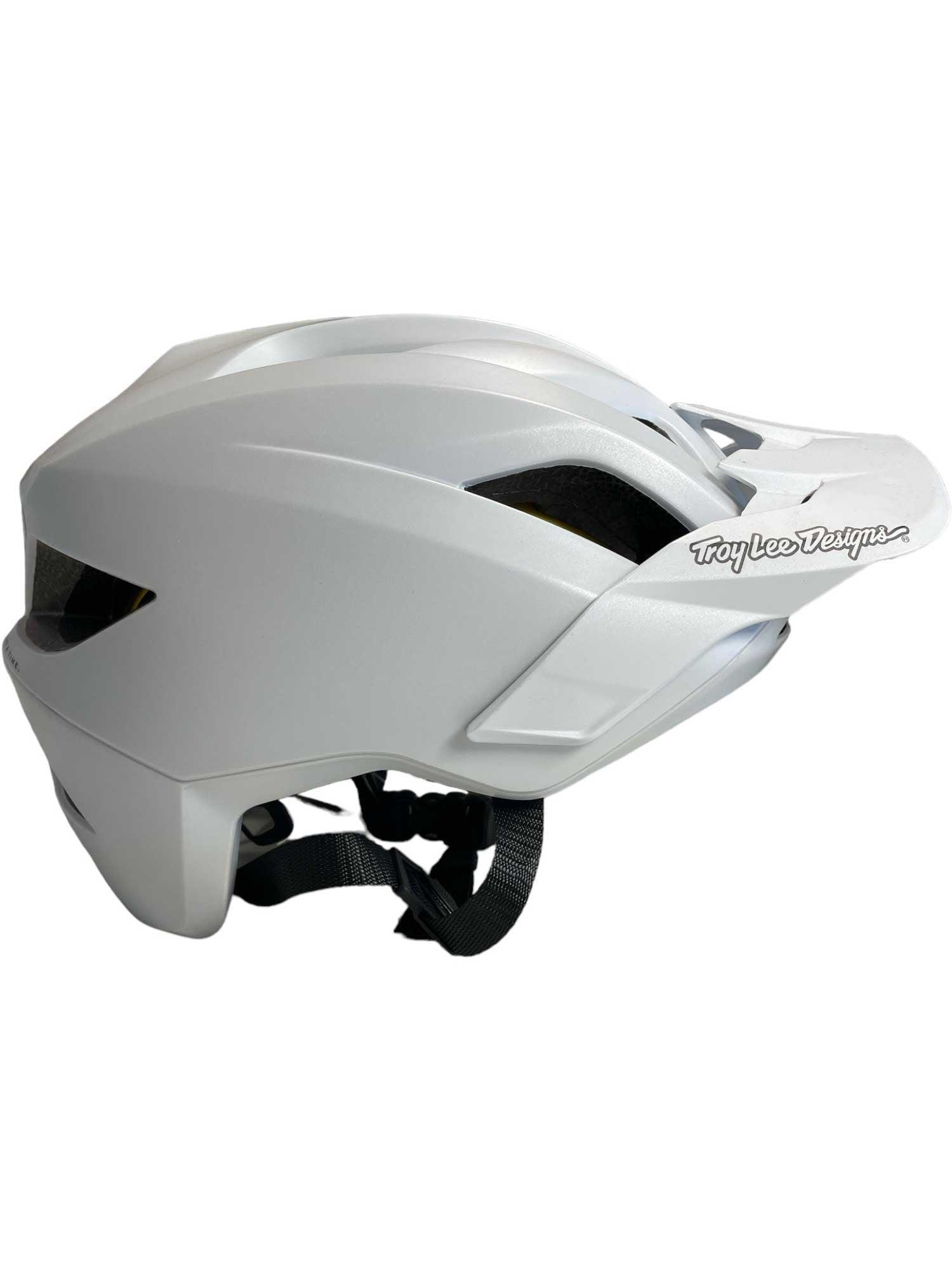 The Troy Lee Designs Flowline with MIPS Orbit Helmet is a white MTB trail helmet with a visor, ventilation slots, and side logo. It features MIPS protection, an adjustable chin strap, and a sleek design—perfect for mountain biking.