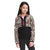 A girl with long dark hair wears The North Face Youth Printed Glacier 1/4 Zip Top in leopard print and black, made from recycled polyester with a pink zipper. She stands with arms relaxed at her sides, looking slightly to her left.