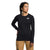 A woman stands with one hand on her hip, looking to the side, wearing The North Face Womens Fd Pro 160 Crew in black and tan pants against a plain white background.