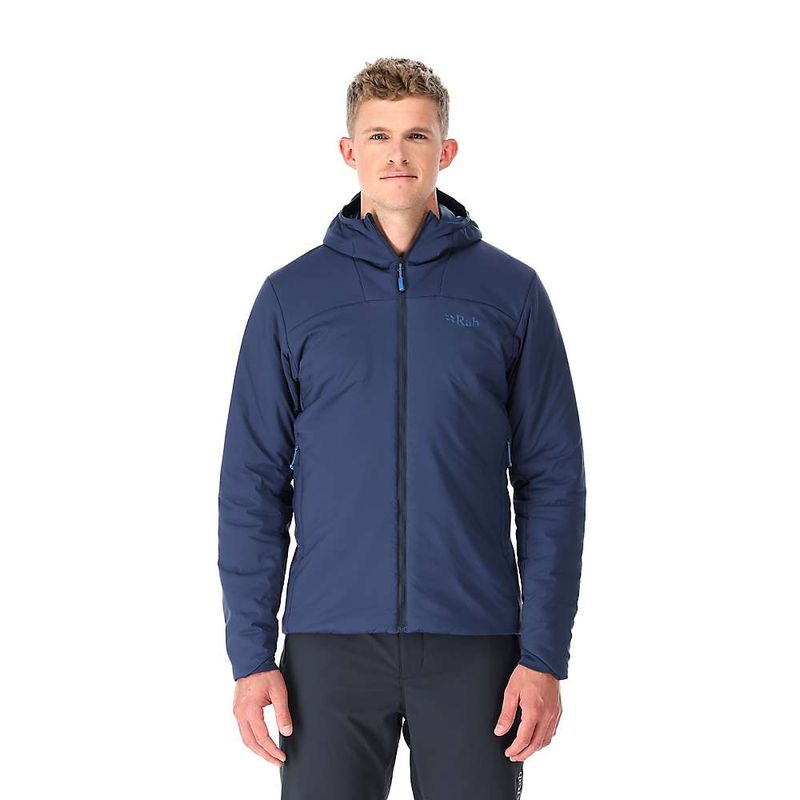 A man faces forward against a plain white background, wearing the Rab Mens Xenair Alpine Light Jacket in navy blue with Primaloft insulation, zipped up, and paired with black pants.